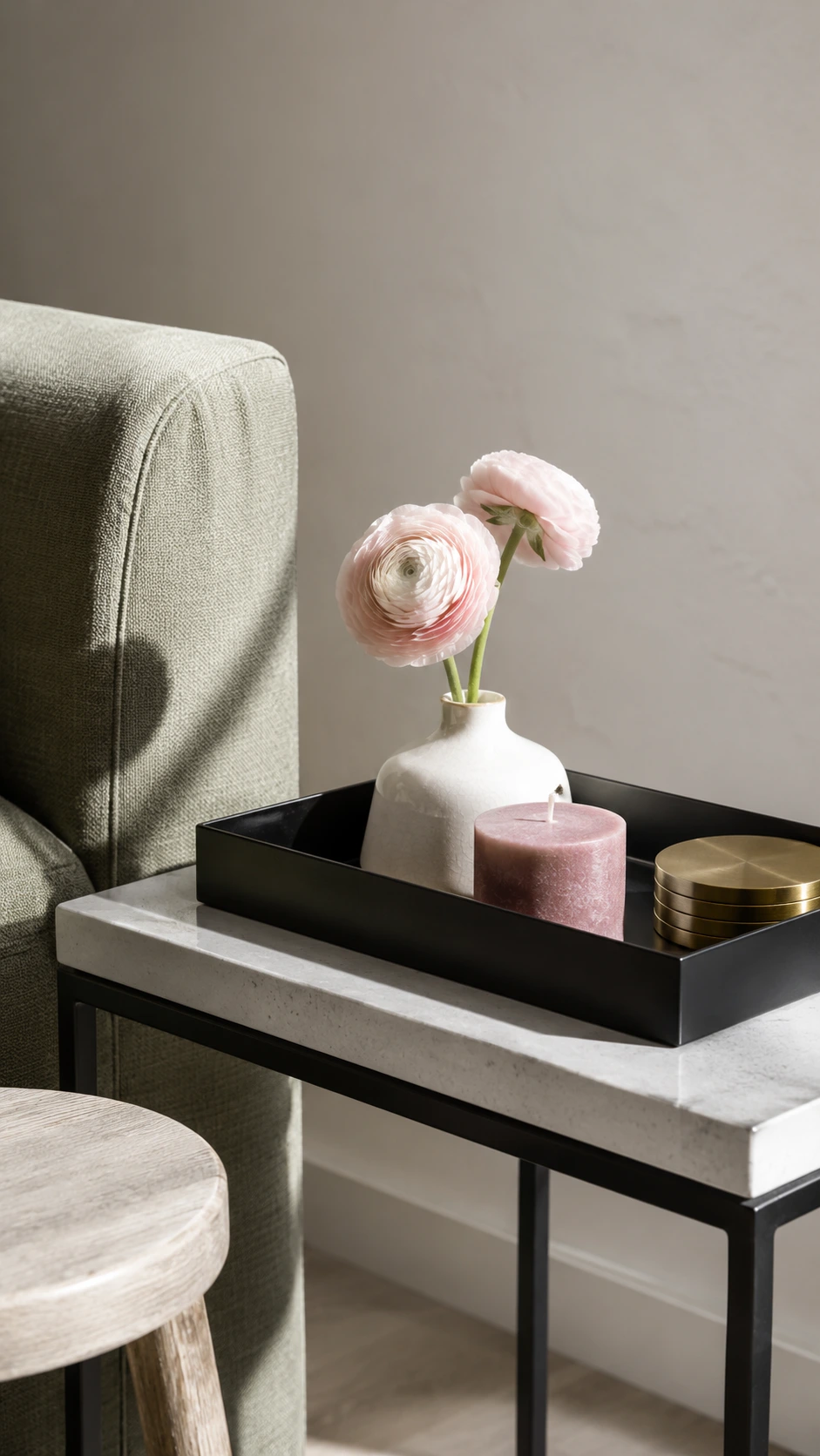 Matte black rectangular tray styled on a sleek side table beside a sage-green sofa, showing how a sofa side table tray anchors a modern living room vignette